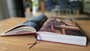 Opengeslagen boek 'Geluid van het Noorden' met kleurrijke afbeeldingen op houten tafel