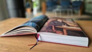 Opengeslagen boek 'Geluid van het Noorden' met kleurrijke afbeeldingen op houten tafel